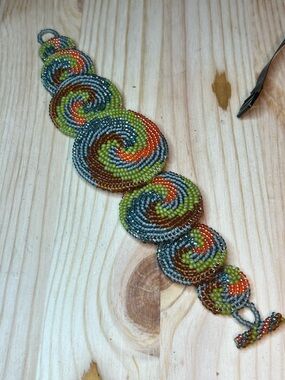 Handmade cuff bracelet with a tribal-inspired geometric spiral pattern